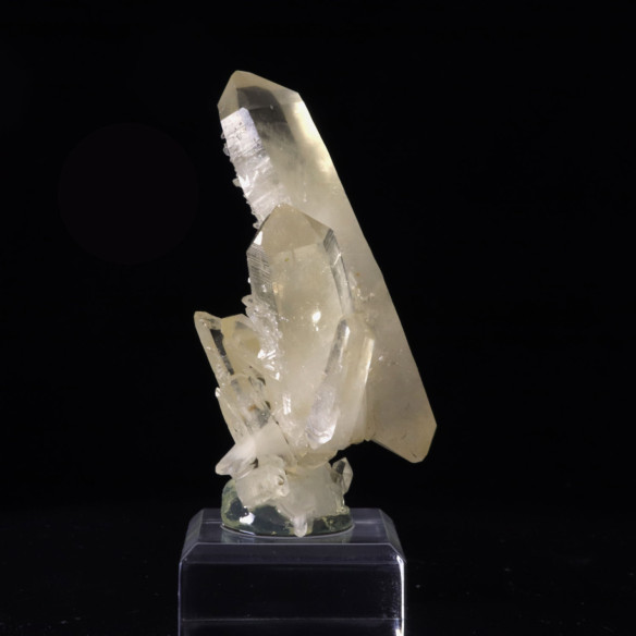 Vue de côté d’un groupe de cristaux de quartz de France sur socle transparent